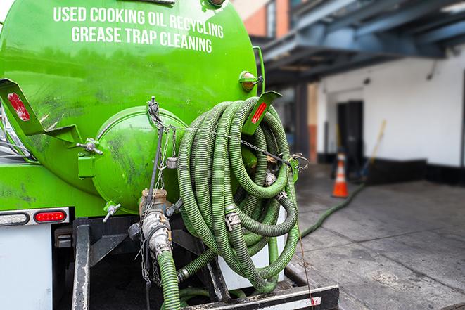 a technician pumping a grease trap in a commercial building in Ellenton FL